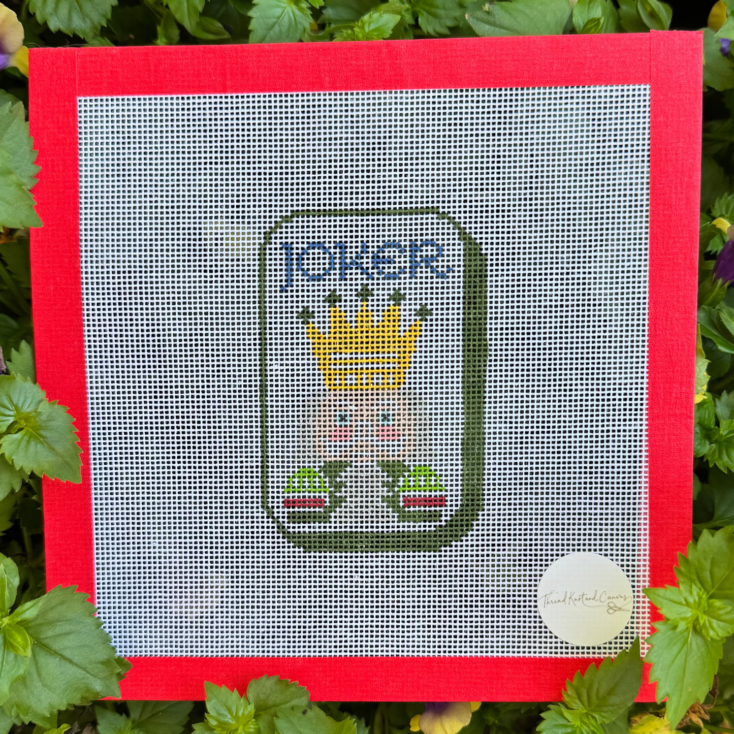 A square cross-stitch canvas featuring a Joker Mahjong Tile with a red border.  