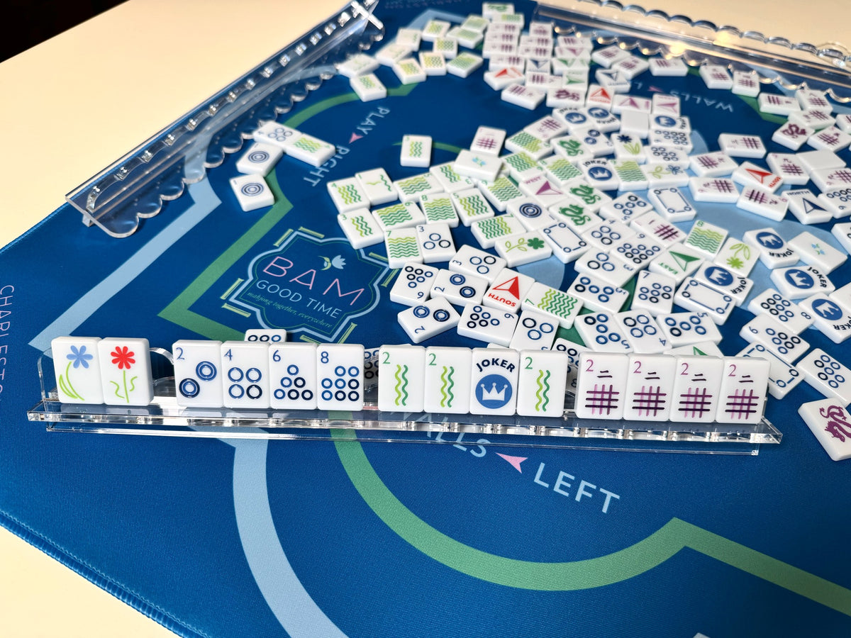 Wild Confetti travel mahjong tiles on an acrylic rack with the full set on a blue mat
